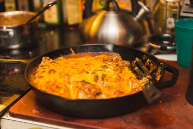 Taze enchiladas veya burrito biber sos ve peynir bir dökme demir tavada kaplı. Ev mutfak ayarı.