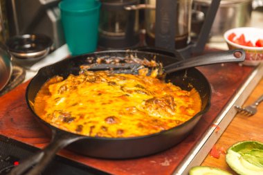 Taze enchiladas veya burrito biber sos ve peynir bir dökme demir tavada kaplı. Ev mutfak ayarı.