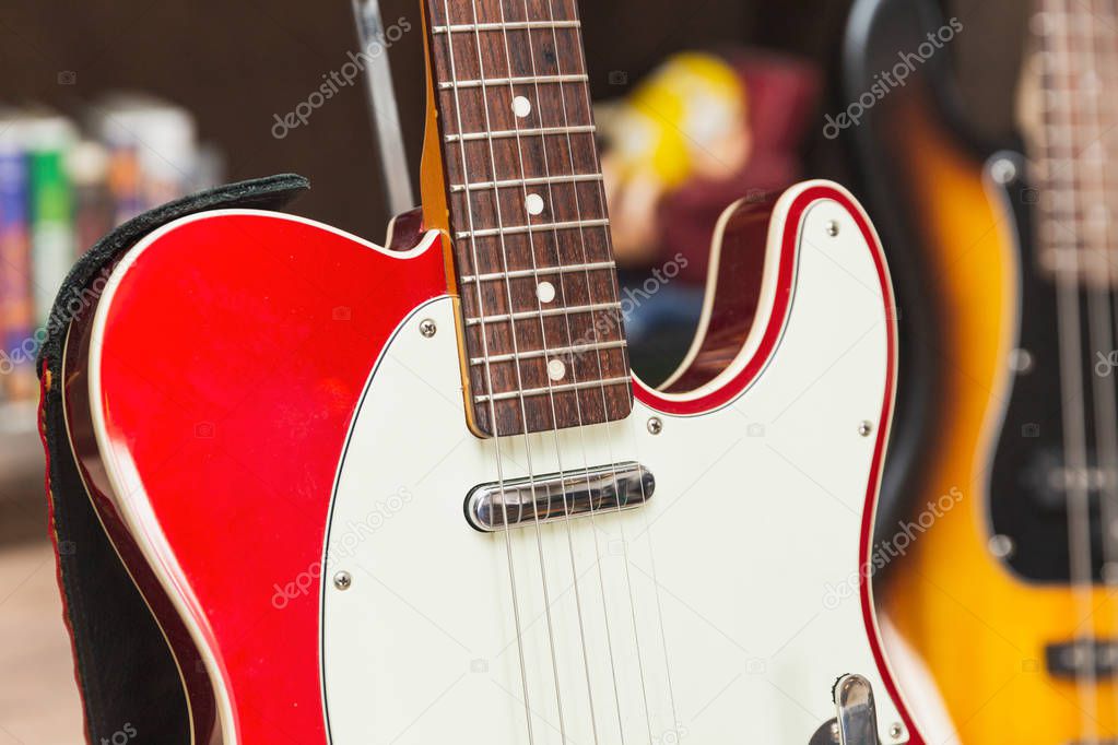 Close up of neck, body, pickup, strings, and pick guard on a modern, vintage, classic electric guitar.