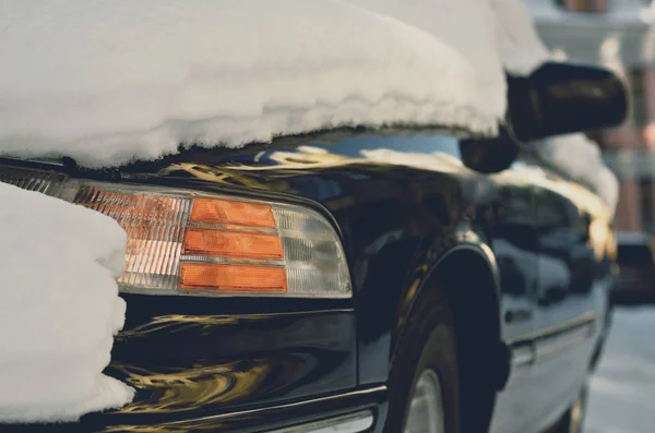 大雪下黑色汽车的前灯 — 图库照片