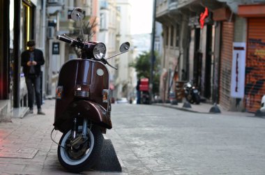 Istanbul, Türkiye - 24 Nisan 2017: kahverengi Piaggio Vespa scooter eski sokakta park