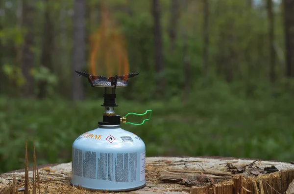 burning camp stove in night forest