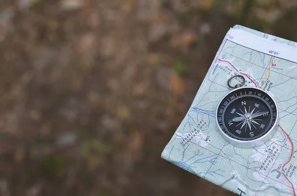 compass and paper map in forest