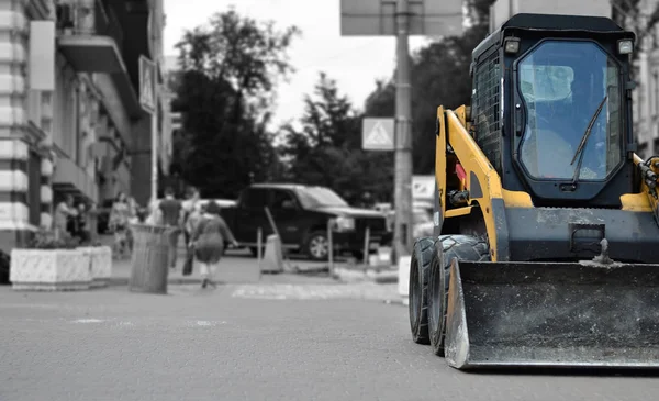 Şehirde bir kova ile traktör