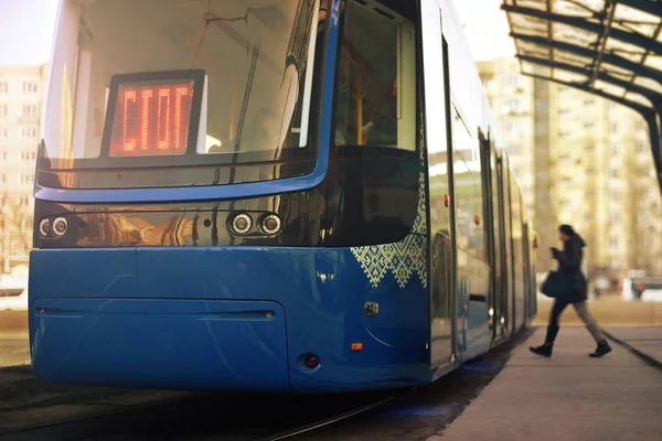 Public transport in city. The woman enters the tram at the stop