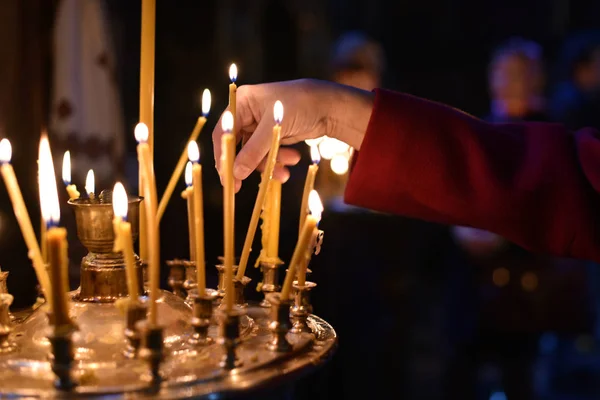 the believer puts a candle on the candlestick in the church
