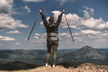 kazanan kadın trekking sopa ile stand üst Dağları üzerinde