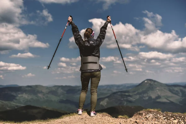 kazanan kadın trekking sopa ile stand üst Dağları üzerinde