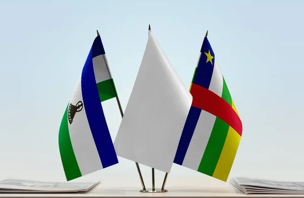 stock image Lesotho Central African Republic and white flags on stand with papers