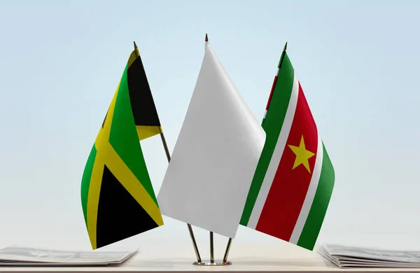 Jamaica Suriname Vlaggen Standaard Met Papieren — Stockfoto