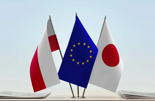 Poland Japan and eu flags on stand with papers