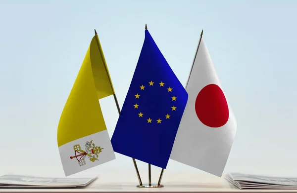 Vatican City Japan and eu flag on stand with papers