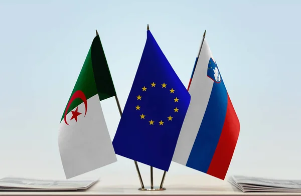 Algeria, Slovenia and eu flags on stand with papers