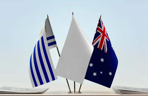 Australia and Uruguay flags on stand with papers