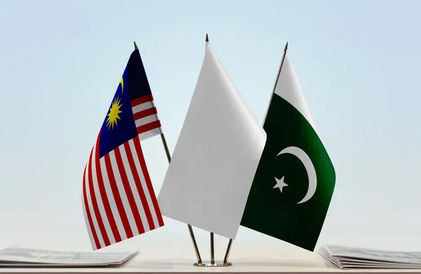 Malaysia Pakistan and white flags on stand with papers