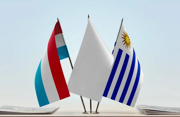 Uruguay and Uruguay flags on stand with papers