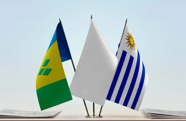 载有文件的圣文森特和格林纳丁斯及乌拉圭国旗摆在讲台上 — 图库照片