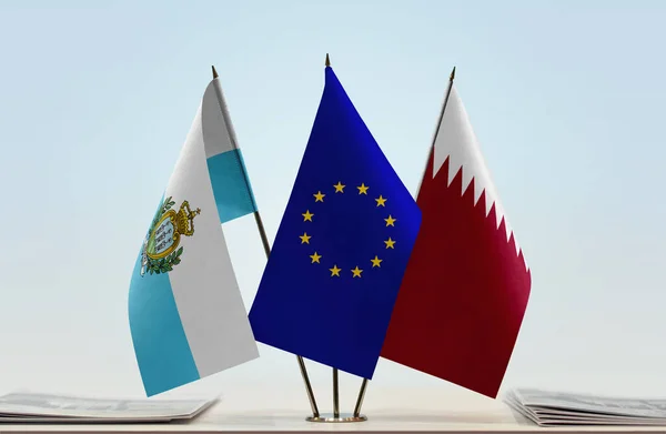 San Marino Qatar and eu flag on stand with papers