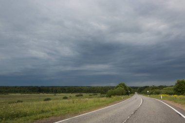 Güzel yaz yatay, kırsal yol ve kötü hava gökyüzü Rusya'da