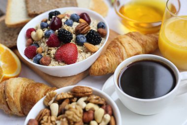 Müsli, meyve, böğürtlen, fındık, kahve, yumurta, bal, yulaf ve diğer yakın çekim ile sağlıklı bir kahvaltı.