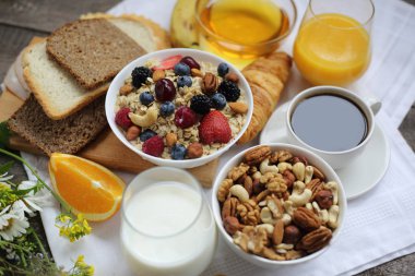 Müsli, meyve, böğürtlen, fındık, kahve, yumurta, bal, yulaf ve diğer yakın çekim ile sağlıklı bir kahvaltı.
