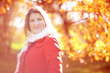 Genç güzel gülümseyen kadın güneşli sonbahar Park