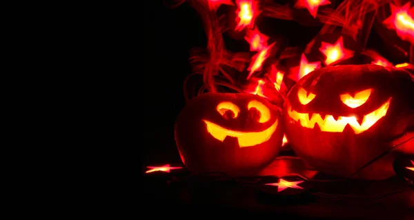 Beleuchteter Niedlicher Halloween Kürbis Und Leuchtende Lichter Auf Schwarzem Hintergrund — Stockfoto