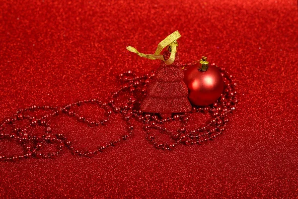 抽象的な赤い光の背景に安物の宝石とおもちゃのもみのクリスマスや新年の装飾 — ストック写真