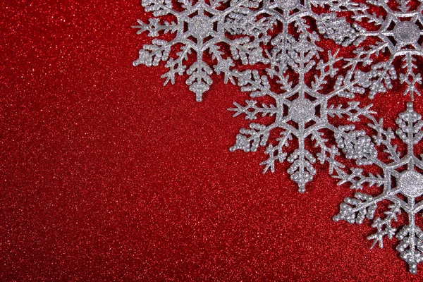 抽象的な赤い光の背景に銀の雪のクリスマスや新年の装飾 — ストック写真
