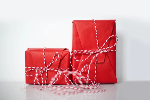 Cajas Regalo Navidad Envueltas Papel Rojo Arco Cuerda Tropezada Sobre —  Fotos de Stock