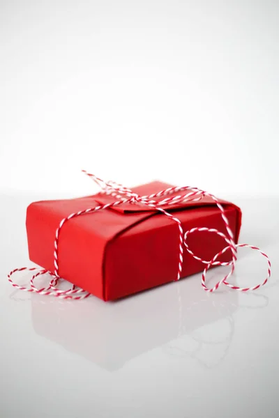 Caixa Presente Natal Embrulhado Papel Vermelho Arco Corda Dtriped Fundo — Fotografia de Stock