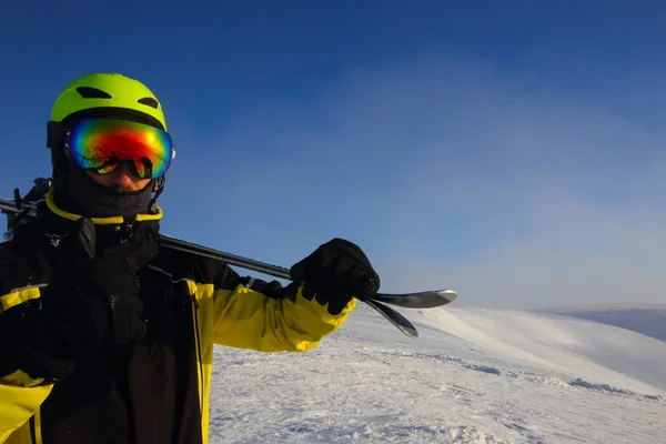 Лыжник Держащий Пару Лыж Смотрящих Горы — стоковое фото