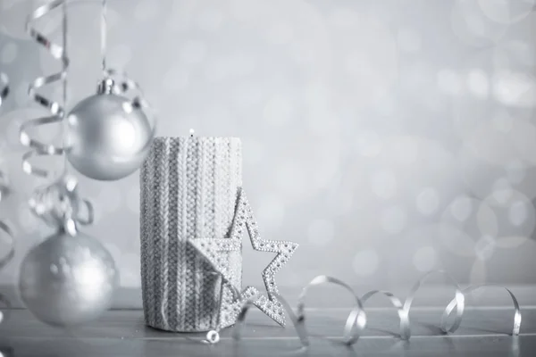シルバークリスマス新年のキャンドルとともに巻きストリーマーリボン弓装飾上のきらびやかなボケライト背景テキストのためのコピースペース — ストック写真