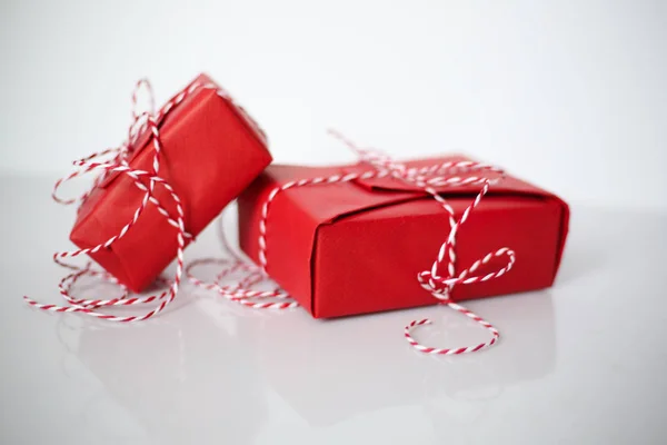 Рождественские Подарочные Коробки Завернутые Красную Бумагу Лук Зубчатой Веревки Белом — стоковое фото