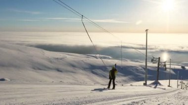 Dağ yamacında teleferik sürükle bar t kullanarak kayakçı