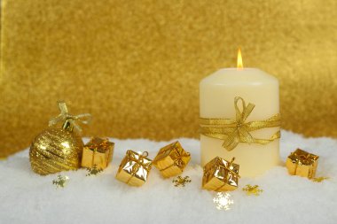 Karda altın Noel dekoru olan Noel mumu parıltılı arka planda