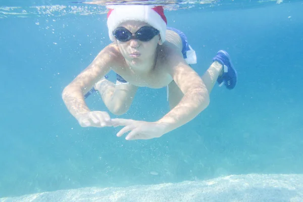 Junge Mit Weihnachtsmann Hut Schwimmt Unter Wasser Meer Weihnachtsurlaub Auf — Stockfoto