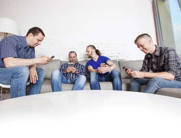 Четверо Счастливых Друзей Мужчин Сидят Дома Диване Используя Свои Мобильные — стоковое фото