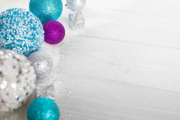 Christmas decoration of colorful glitter balls and snow on wooden background with copy space for text new year card concept