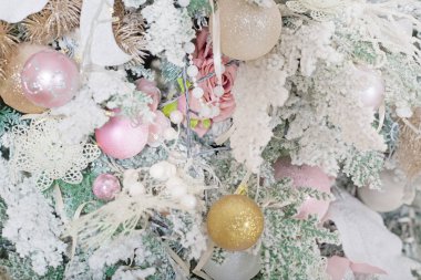 Güzel köknar ağacı, pembe ve bej rengi soluk renklerle süslenmiş Noel odası.