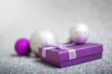 Renkli sim toplarının Noel süslemesi ve gümüş parıltılı arka planda yeni yıl kartı konsepti için fotokopi alanı ile hediye