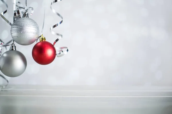 シルバーと赤のクリスマスの新年のボールとともに巻きストリーマーリボン弓上のきらびやかなボケライト背景とともにコピースペースのためのテキスト — ストック写真