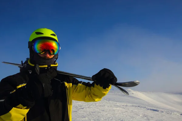 Лыжник Держащий Пару Лыж Смотрящих Горы — стоковое фото