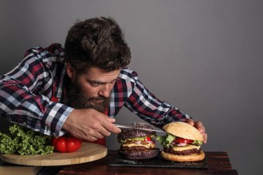 Taze pişmiş siyah burger pişiren adam.