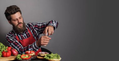 Taze hamburgerleri pişiren adam.