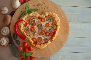 Jambon domatesli ve ahşap kaplamalı mantarlı pizza kalbi. Sevgililer Günü için romantik aşk kavramı. Aşk yemeği.