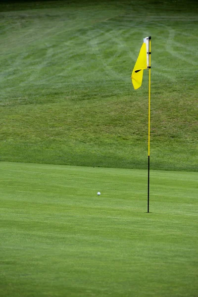 Bandeira de golfe na grama verde — Fotografia de Stock