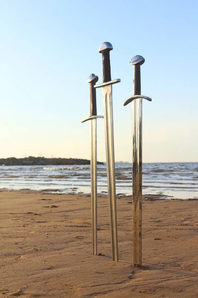 Tři meče v písku na bitevním poli — Stock fotografie