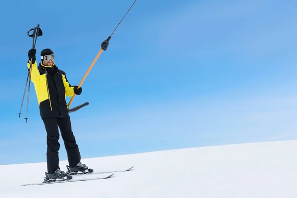 Happy skier using T-bar ski drag lift