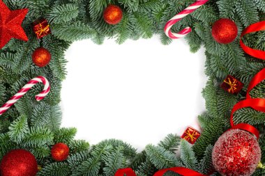 Soylu köknar dallarının ve beyaz arka planda izole edilmiş kırmızı takıların Noel tasarımı boder çerçeve tebrik kartı